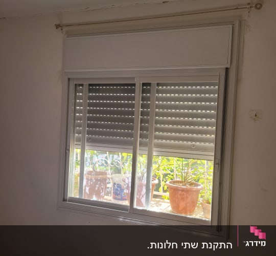 חלון אלומיניום עם תריסים סגורים חלקית